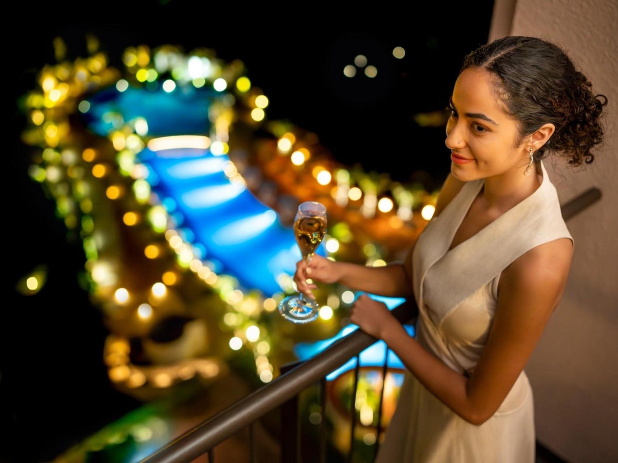 Oriental Hotel Okinawa Resort & Spa Nago Exterior foto A woman holding a glass of champagne